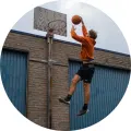 Kulatý jedlý obrázek na dort – Basketbal, smeč u cihlové zdi (modrá, hnědá, černá)
