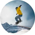 Kulatý jedlý obrázek na dort – Snowboard, jezdec ve žluté bundě na railu (modrá, žlutá, bílá)