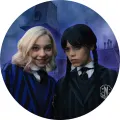 Kulatý jedlý obrázek na dort – Wednesday, s Enid před Nevermore (modrá, černá, fialová)
