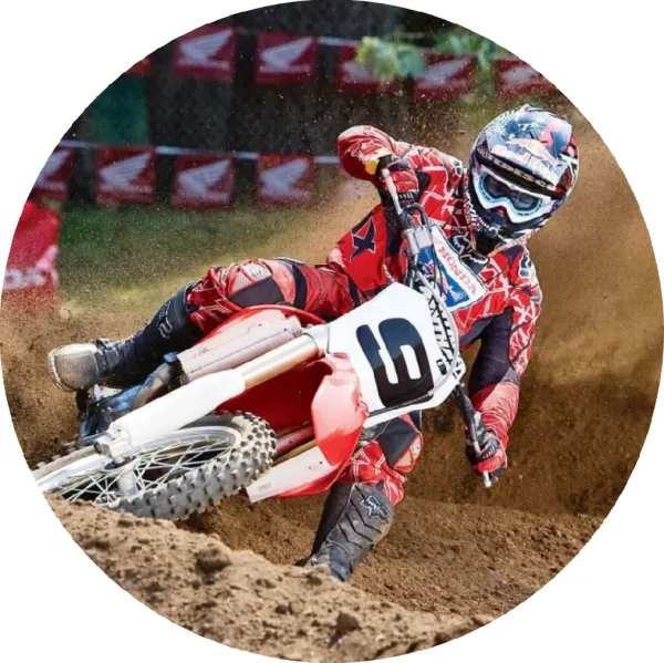 Kulatý jedlý obrázek na dort – Motorka, červenobílý motokros na trati (červená, hnědá, bílá)