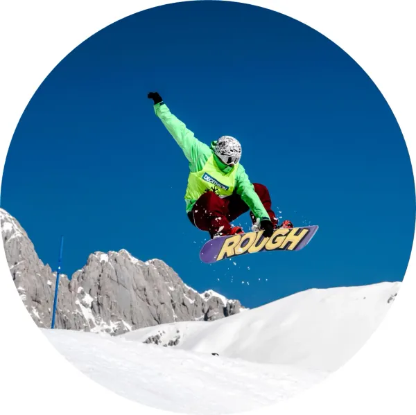 Kulatý jedlý obrázek na dort – Snowboard, jezdec v zelené bundě ve vzduchu (modrá, bílá, zelená)